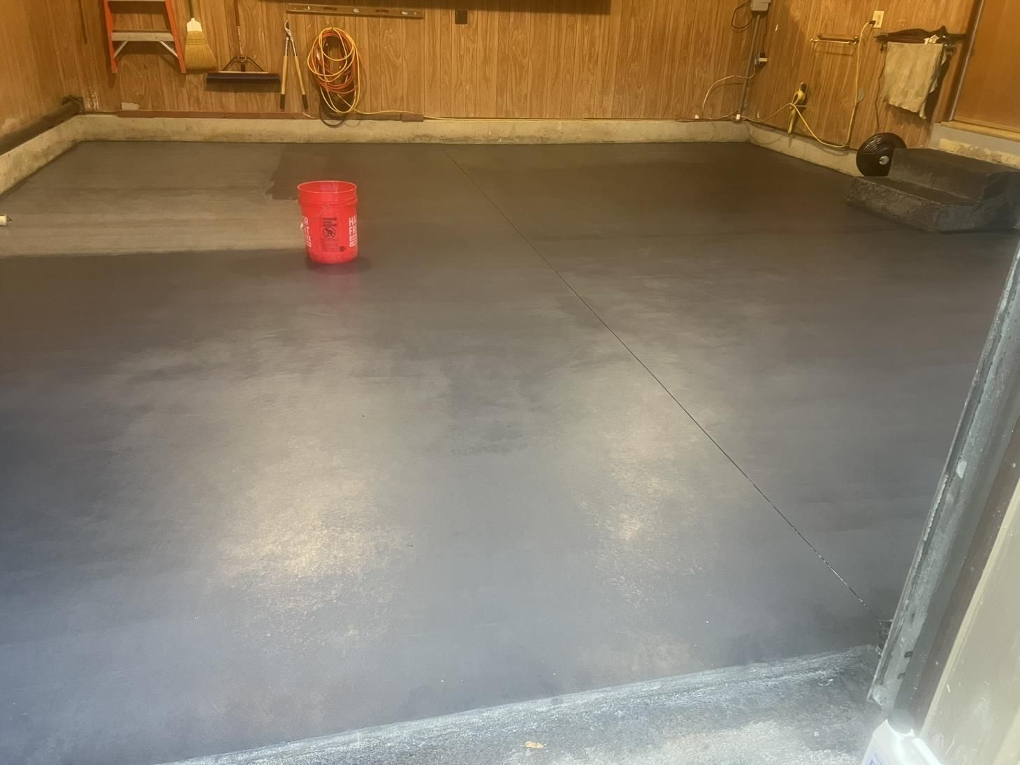 A man is using a trowel to spread concrete on a sidewalk.