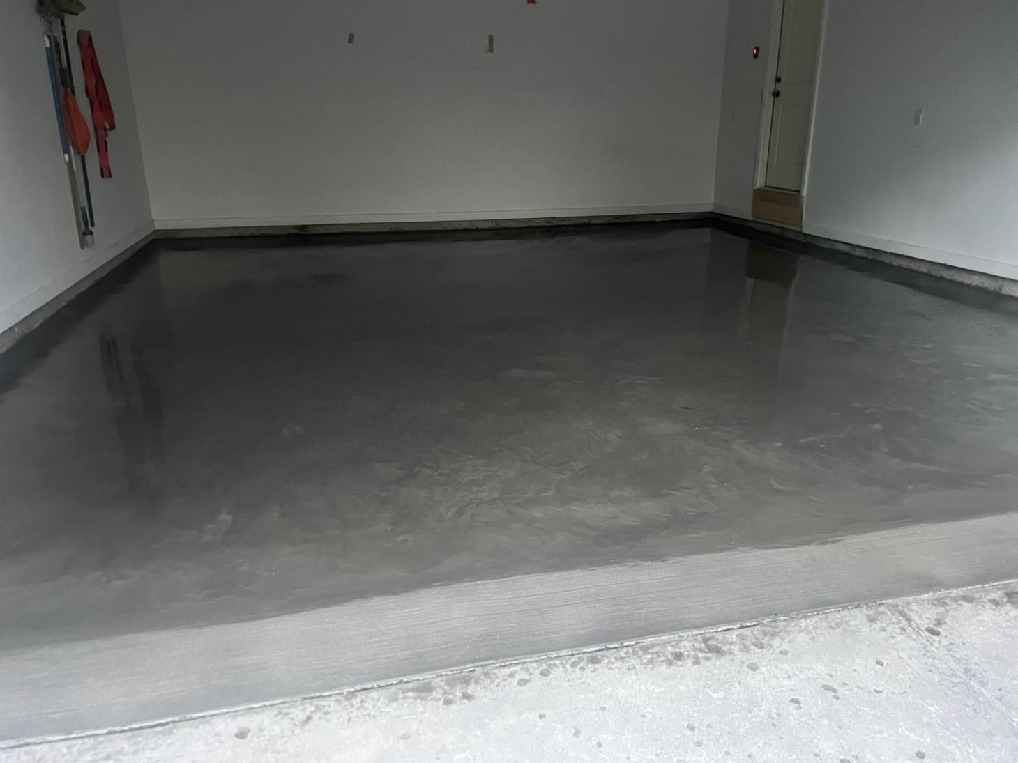 A man is pouring concrete into a wooden frame.