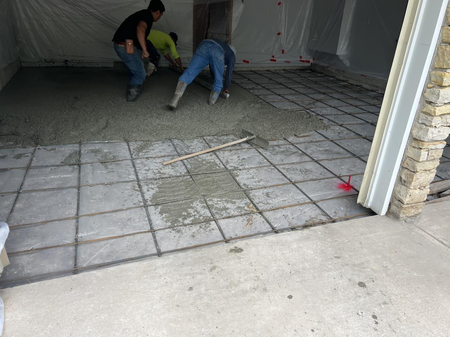 A man is pouring concrete into a wooden frame.