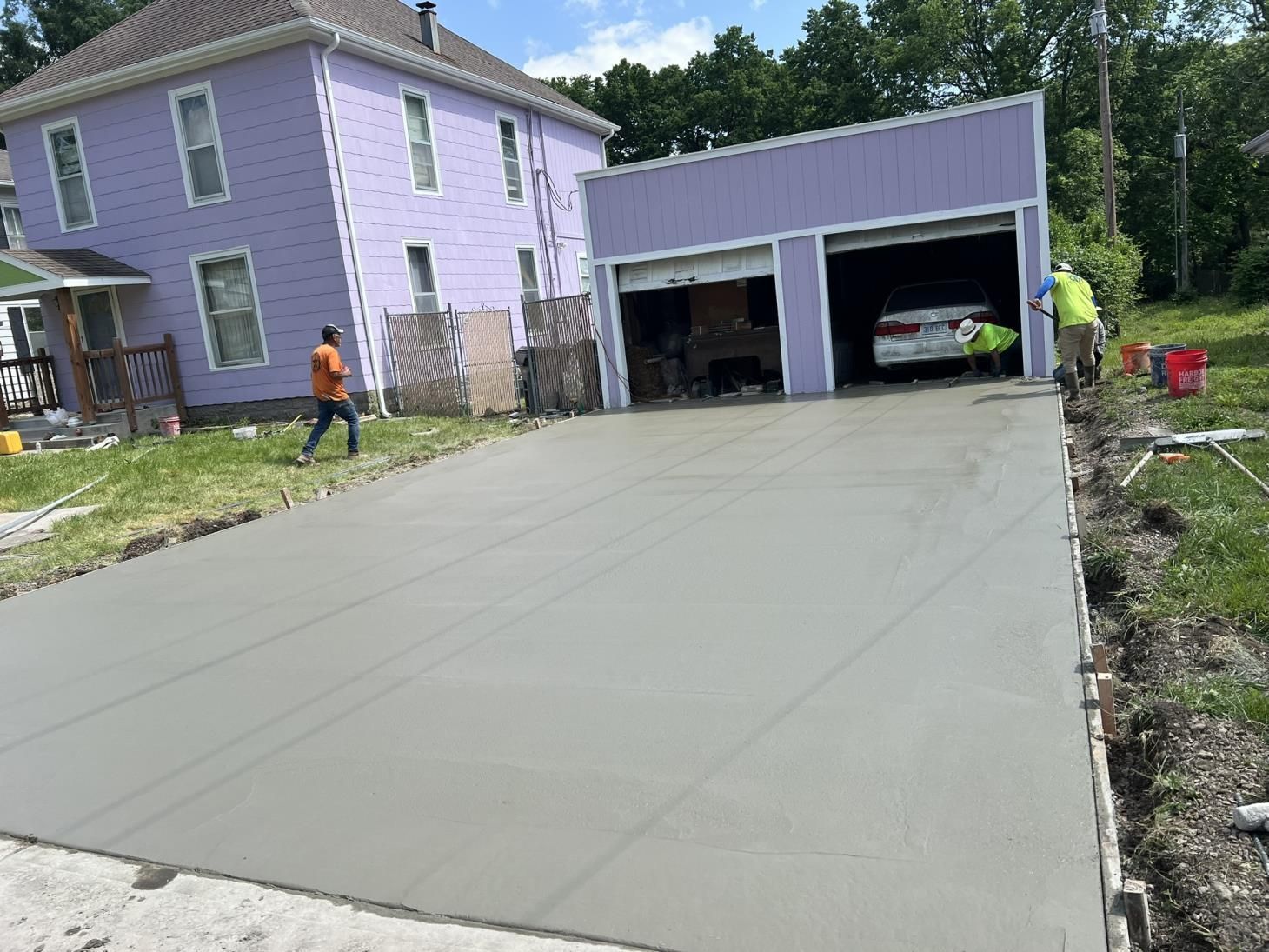 A man is pouring concrete into a wooden frame.