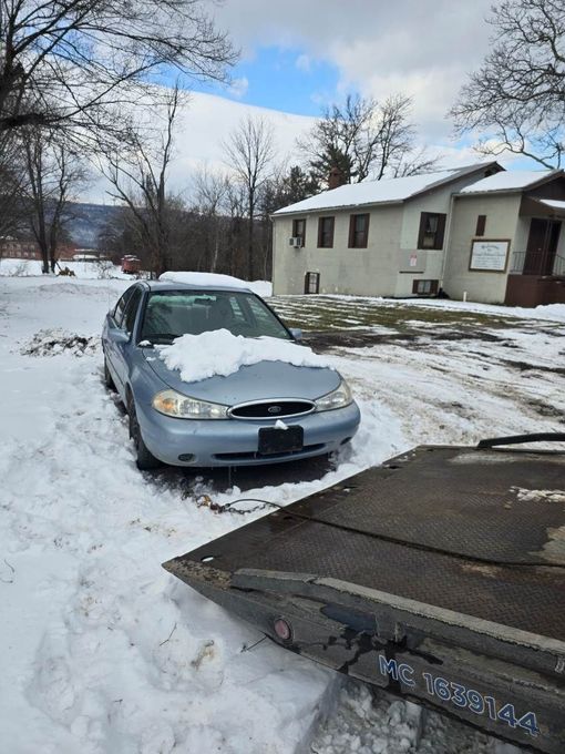 A car is sitting on a tow truck in the snow