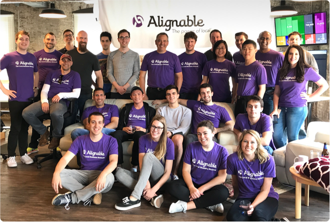 A group of people wearing purple shirts are posing for a picture.
