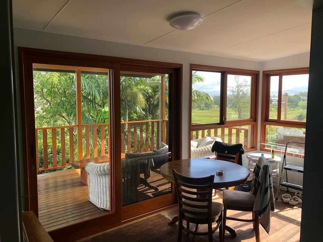 A Dining Room with A Table and Chairs and A View of A Deck — Green e Building in Byron Bay, NSW