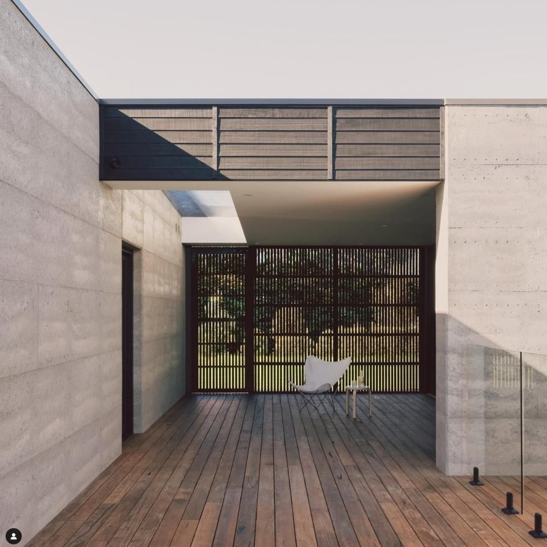 A Chair Sits On A Wooden Deck In Front Of A Fence — Green e Building in Lennox Head, NSW
