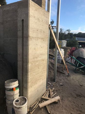 A Concrete Wall Is Being Built Next To A Wheelbarrow And Buckets — Green e Building in Lennox Head, NSW