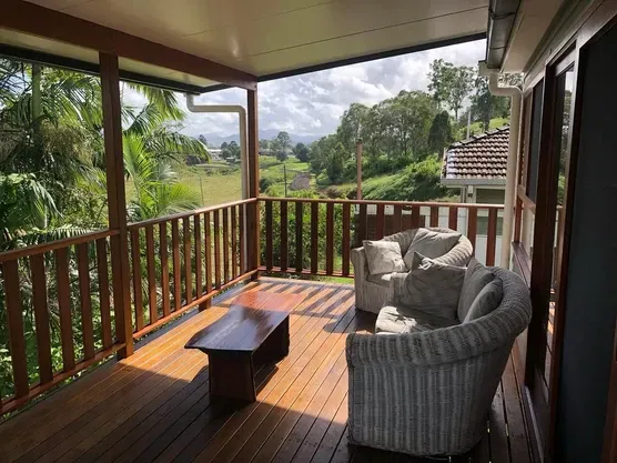 A Wooden Deck With A Couch And Chairs On It — Green e Building in Lennox Head, NSW