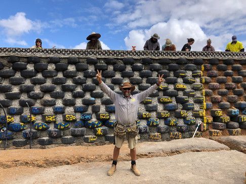 A Man Is Standing in Front of A Wall Made out Of Tires — Green e Building in Lennox Head, NSW