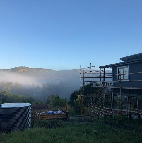 A House With Scaffolding In Front Of It And A Water Tank In The Background — Green e Building in Lennox Head, NSW
