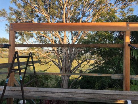 A Wooden Fence Is Being Built In Front Of A Tree — Green e Building in Lennox Head, NSW