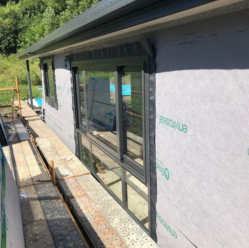 A House Is Being Built With A Lot Of Windows And Scaffolding — Green e Building in Lennox Head, NSW