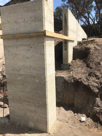 A Concrete Wall Is Being Built On Top Of A Dirt Hill — Green e Building in Lennox Head, NSW