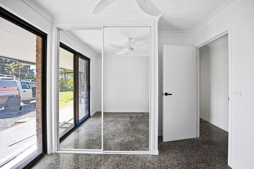 An Empty Room With A Ceiling Fan And Sliding Glass Doors — Green e Building in Lismore, NSW