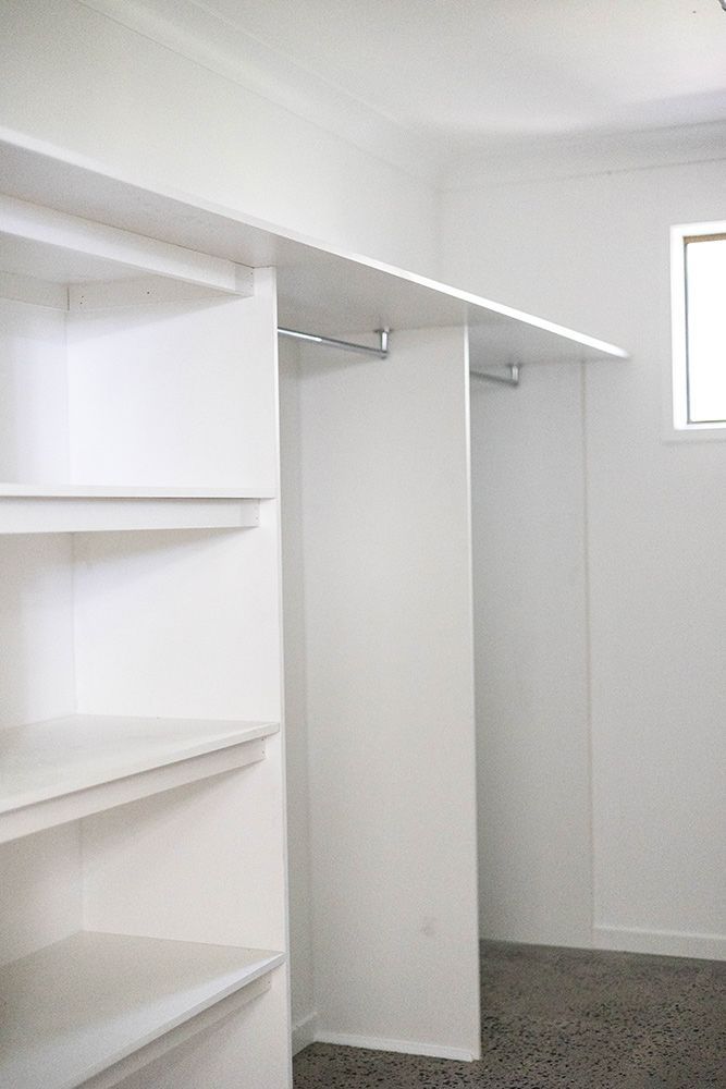 An Empty Walk In Closet With White Shelves And A Window — Green e Building in Casino, NSW