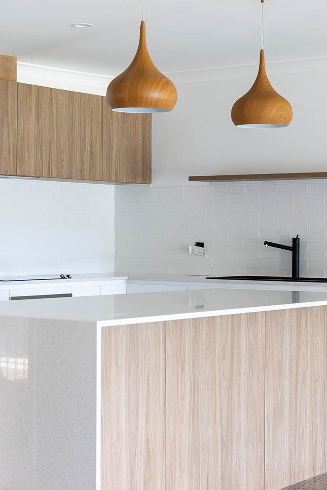 A Kitchen With Wooden Cabinets And A White Counter Top — Green e Building in Bangalow, NSW