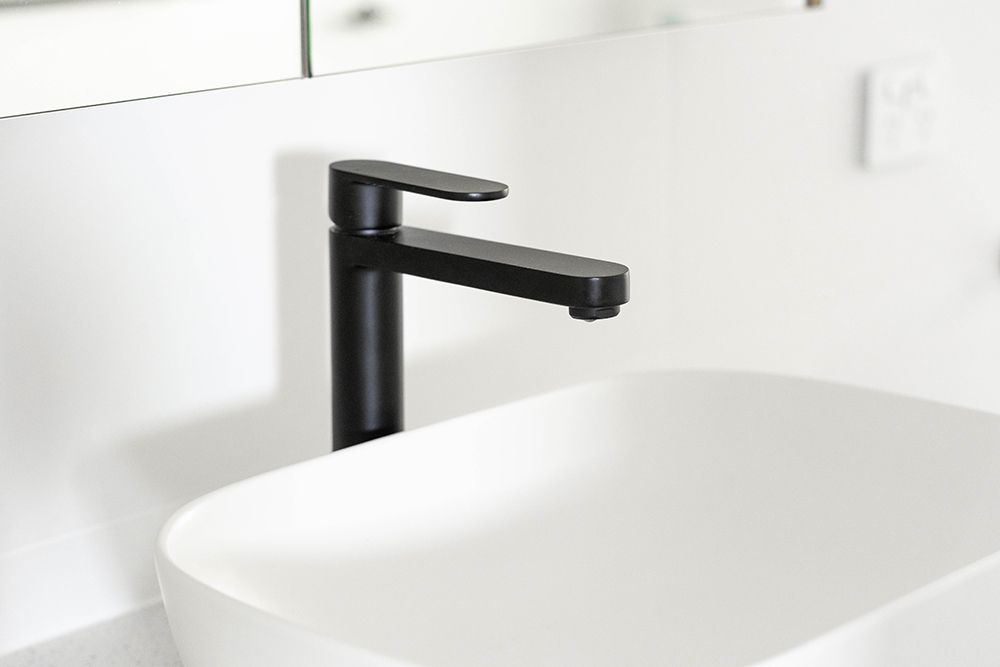 A Bathroom Sink With A Black Faucet And A Mirror — Green e Building in Mullumbimby, NSW