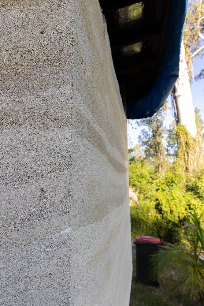 A Close Up Of A Concrete Wall With Trees In The Background — Green e Building in Lennox Head, NSW