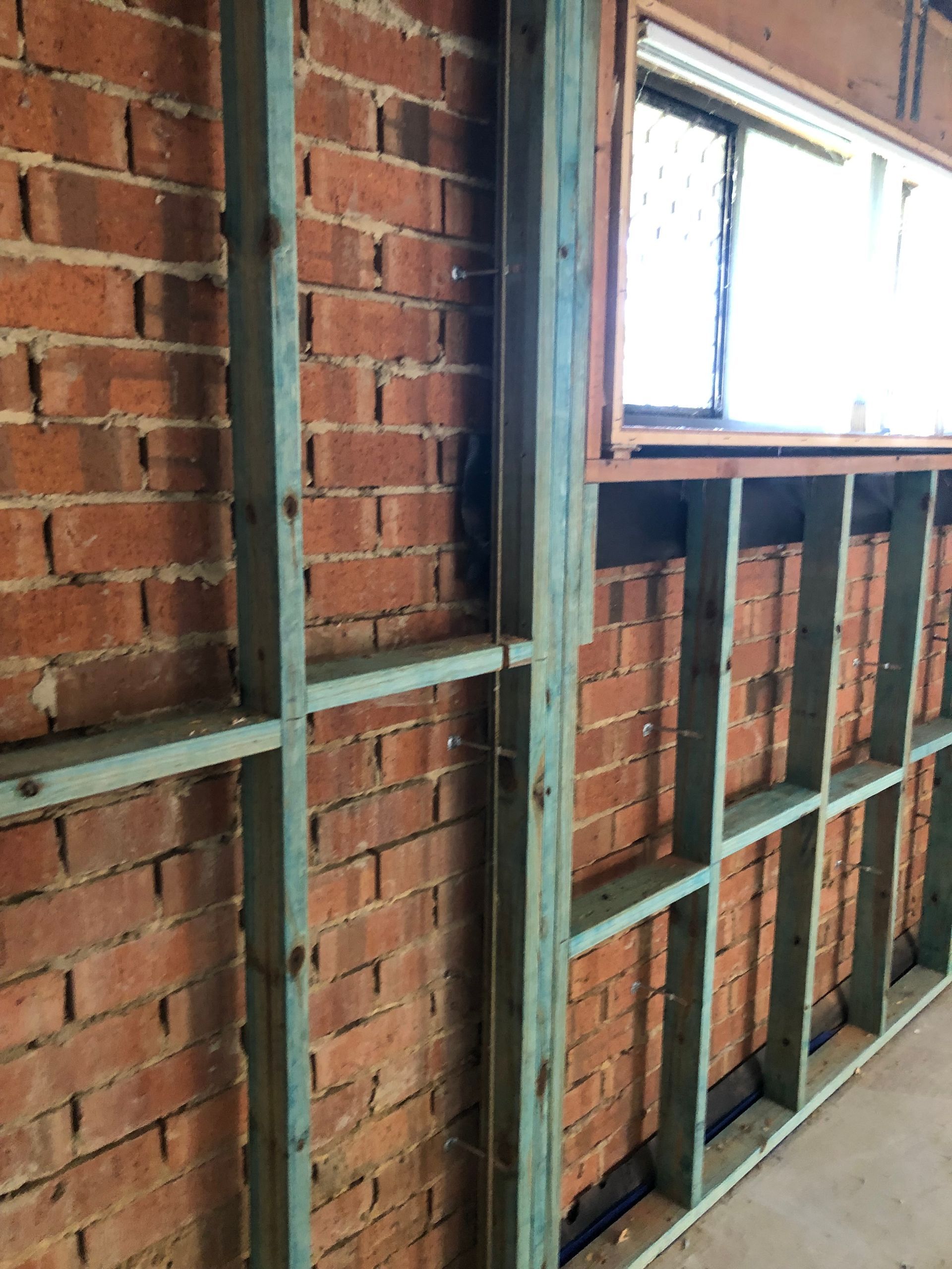 An Empty Kitchen With White Cabinets And A Ceiling Fan — Green e Building in Lennox Head, NSW