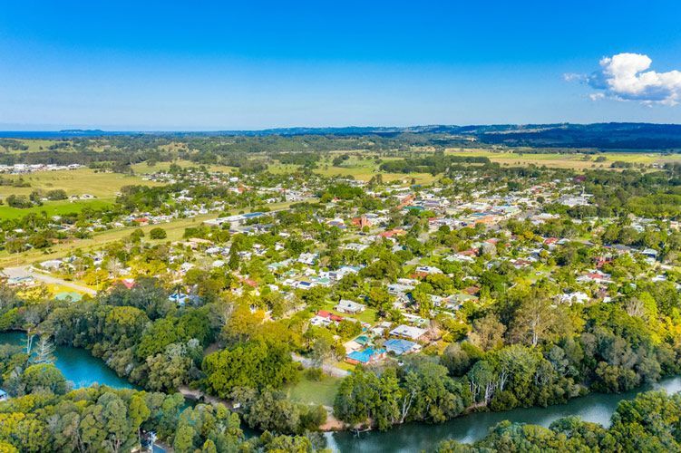 An Aerial View Of A Small Town Surrounded By Trees And A River — Green e Building in Mullumbimby, NSW