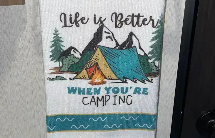 Towel with camping scene: tent, campfire, mountains, trees, teal and yellow details