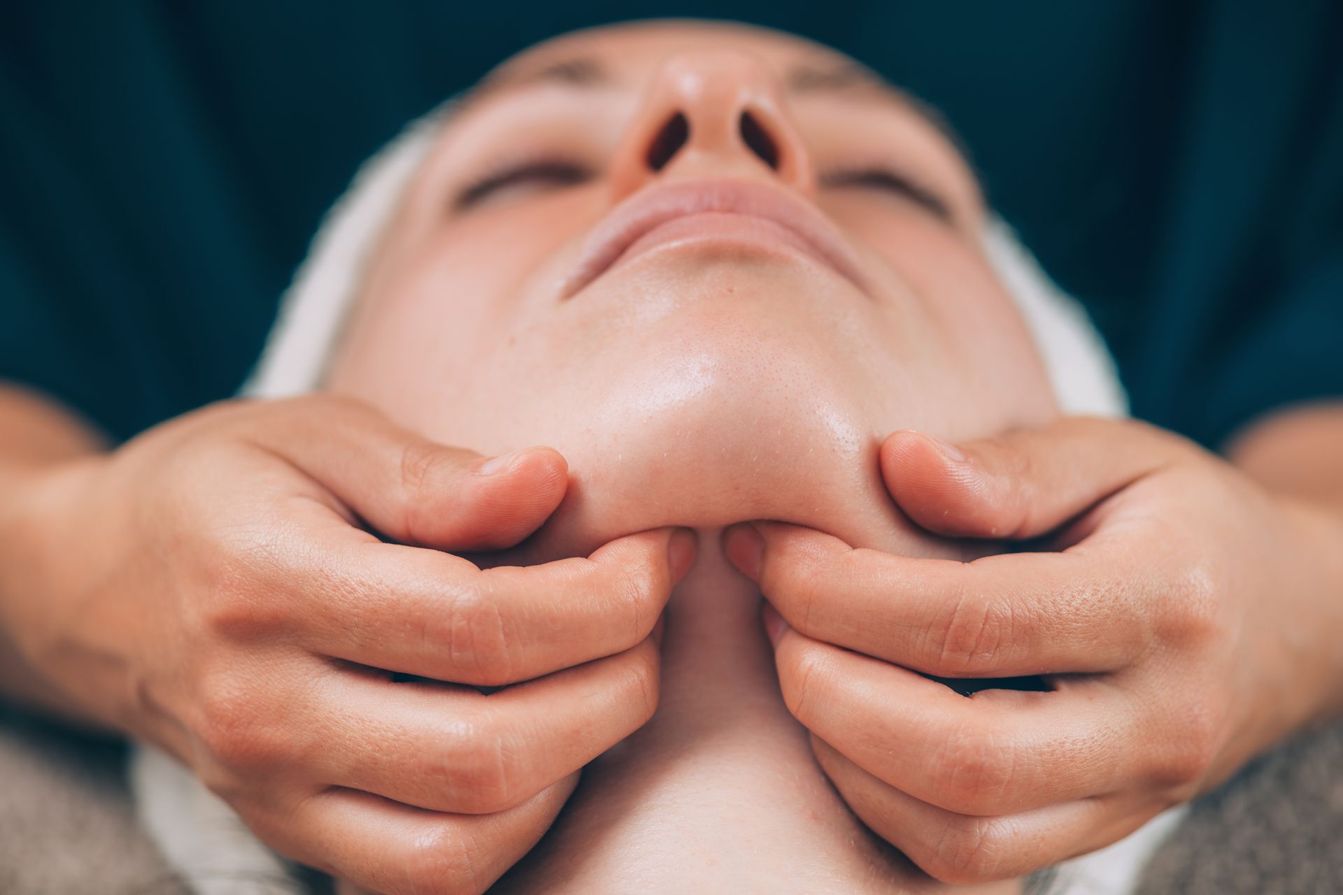 A woman is getting a facial massage at a spa.