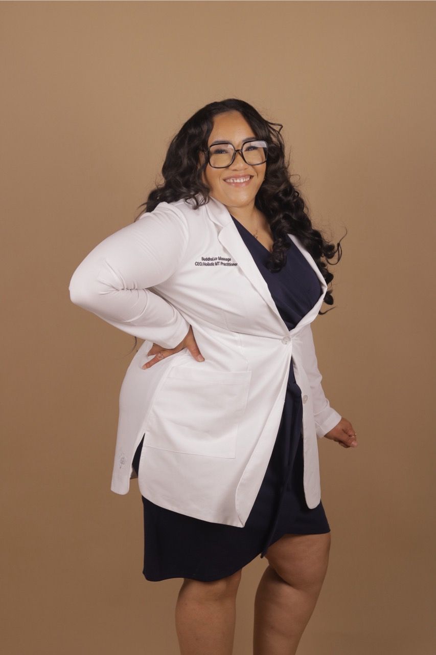 A woman wearing a white lab coat and glasses is standing with her hands on her hips.