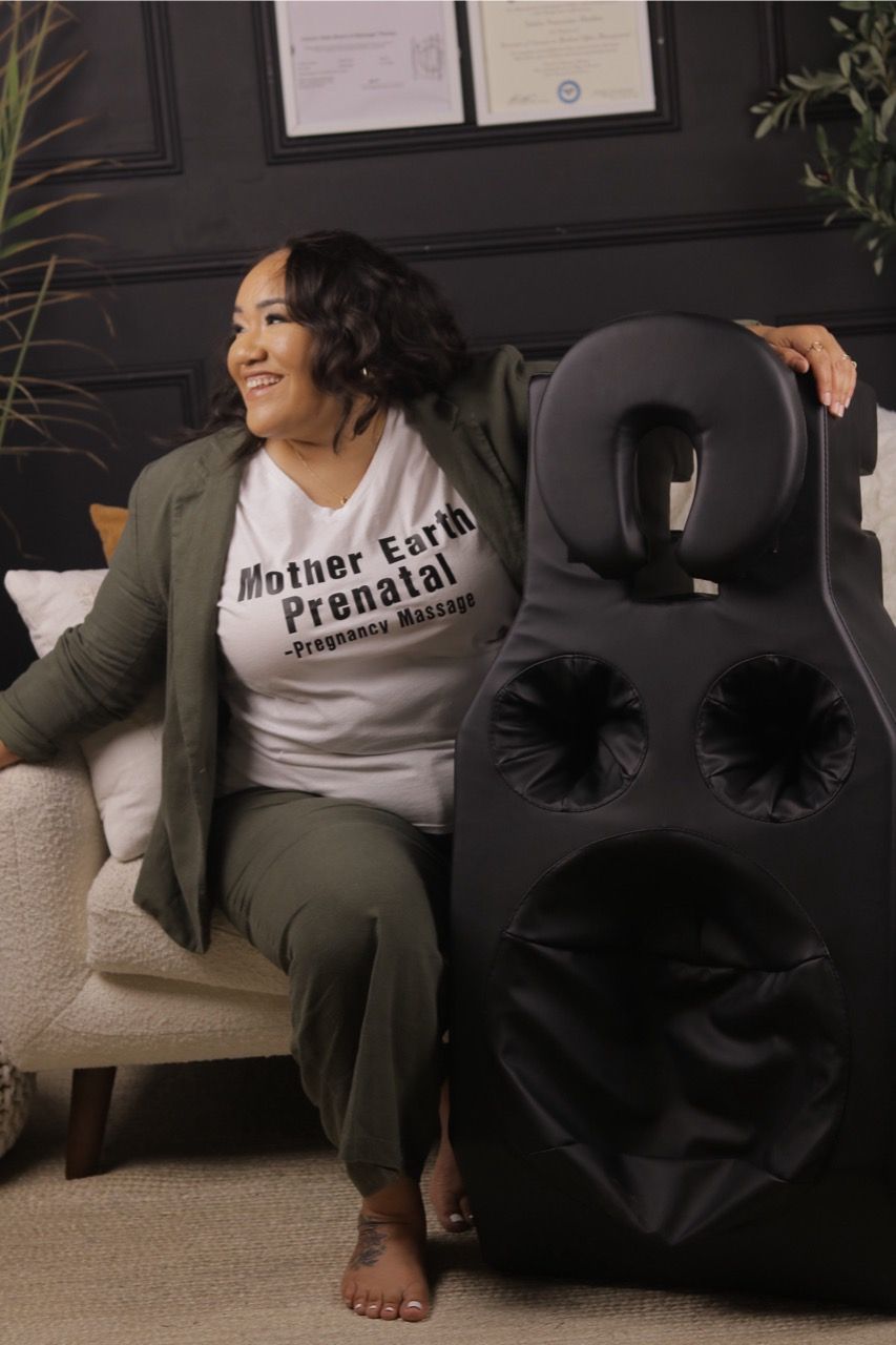 A woman is sitting on a couch next to a large speaker.