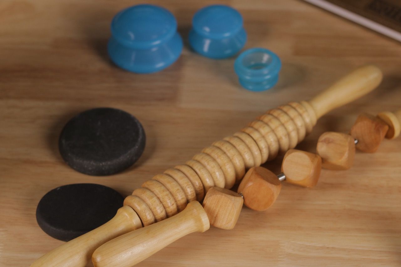 A wooden massage roller is sitting on a wooden table