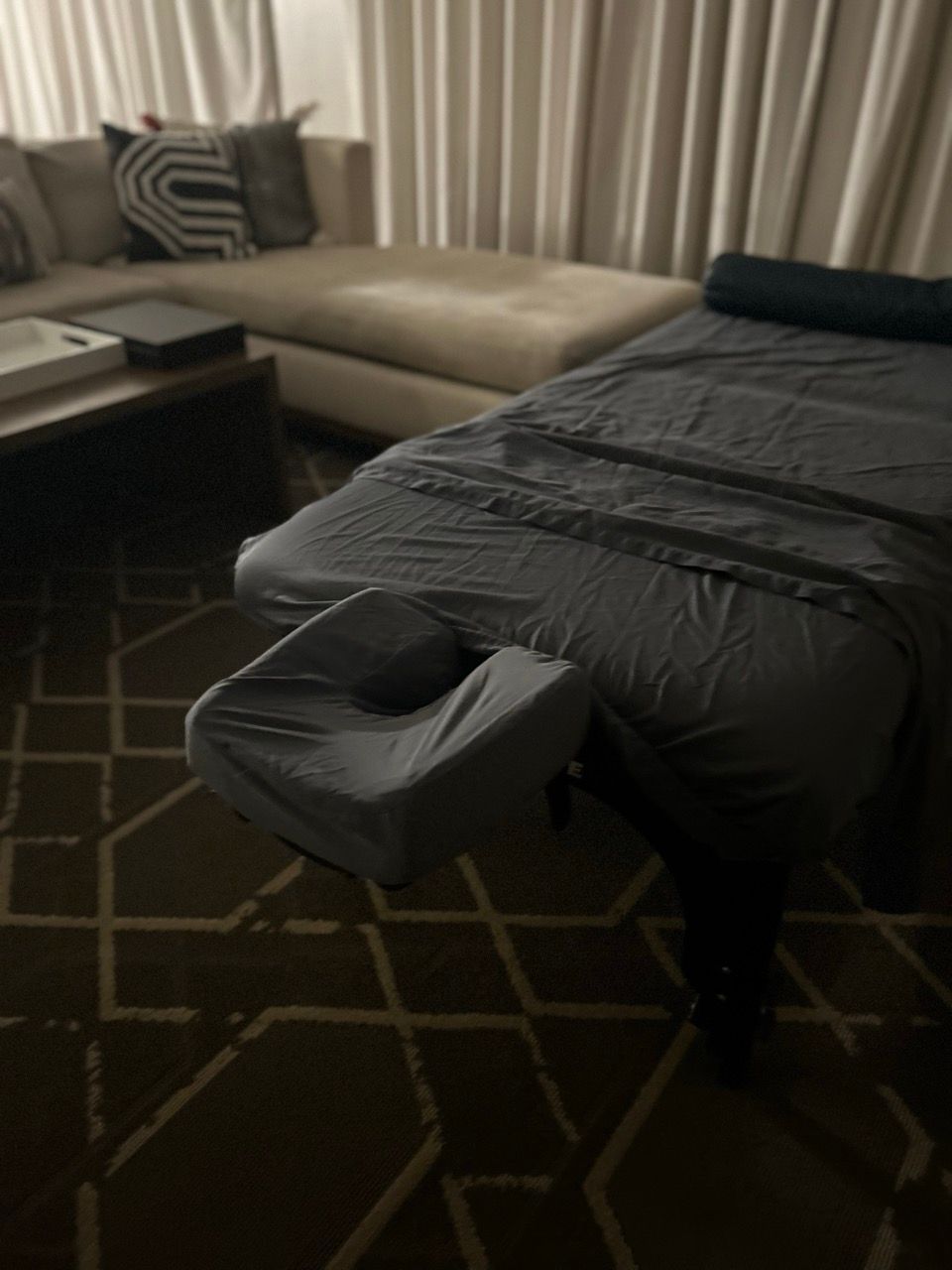 A massage table in a living room next to a couch