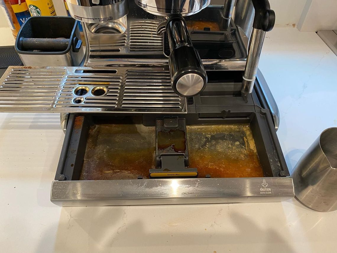 A dirty coffee machine is sitting on a counter.