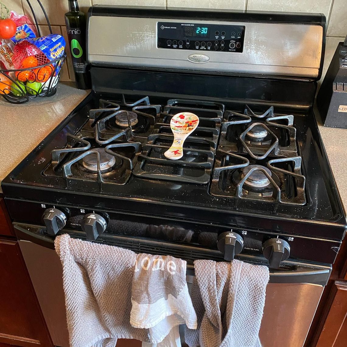 A stove top oven with a towel hanging on the door.