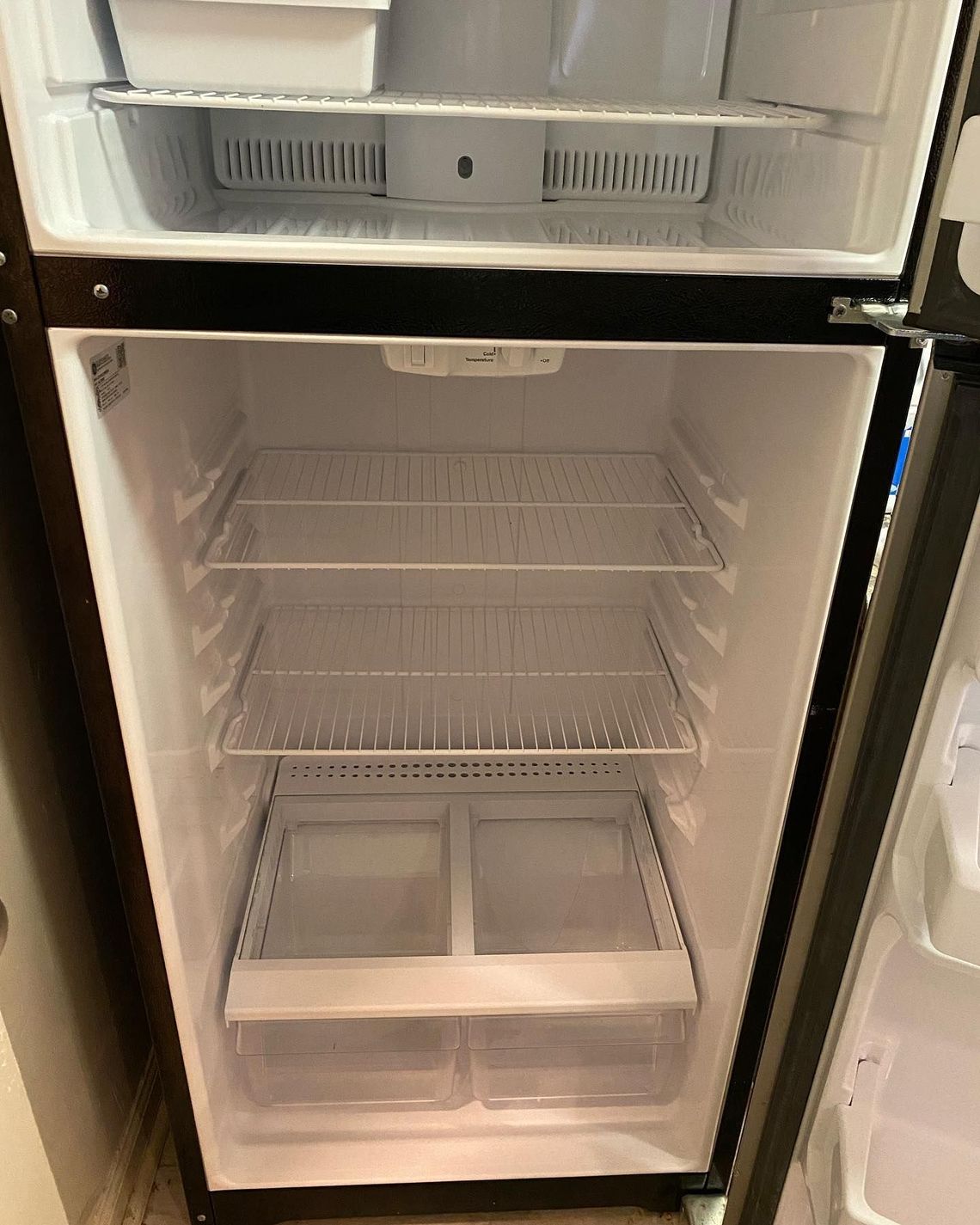 The inside of an empty refrigerator with the door open.