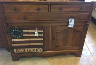 A wooden cabinet with a flag on it and the words `` old glory '' written on it.