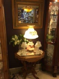 A lamp is sitting on a table in a room next to a mirror.