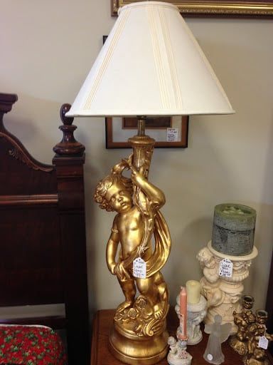 A lamp with a cherub on it is sitting on a table.