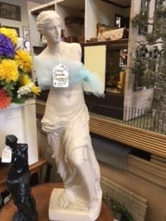A statue of venus is sitting on a table in a store.