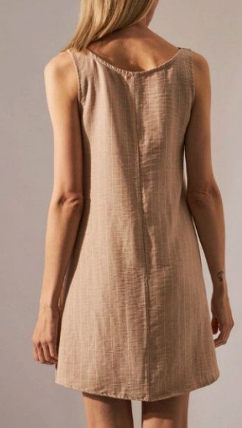 Vestido sin mangas de color canela con rayas verticales, escote redondo, usado por una persona.