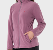 Una mujer lleva una chaqueta de polar violeta y tiene las manos en los bolsillos.