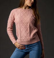 Una mujer lleva un suéter rosa y jeans azules.