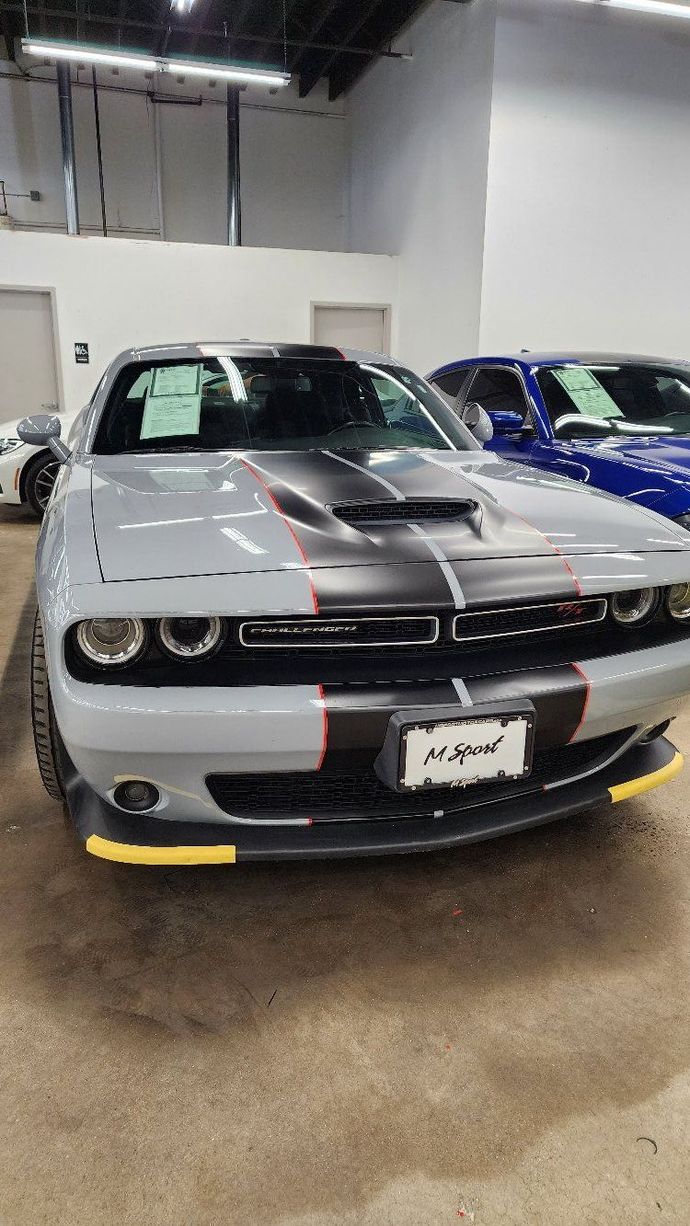 a gray dodge challenger is parked in a garage .