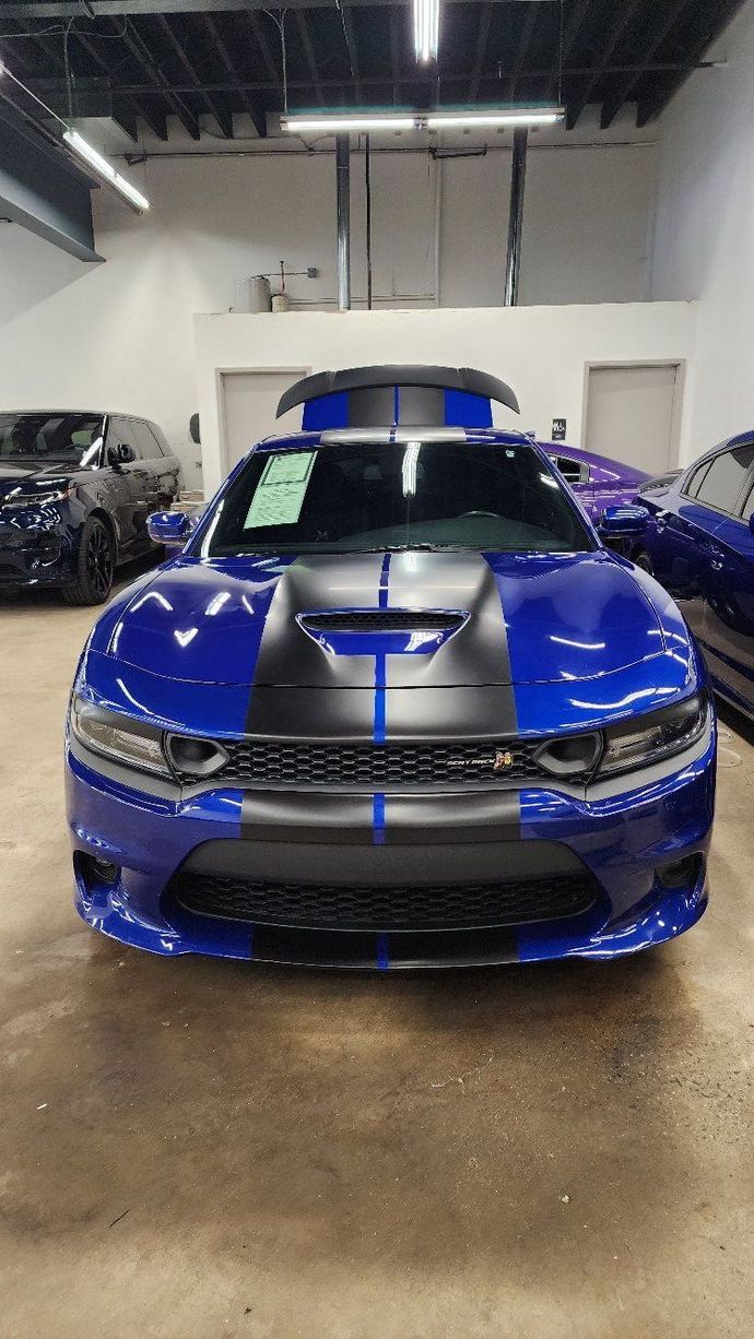 a blue dodge charger is parked in a garage .