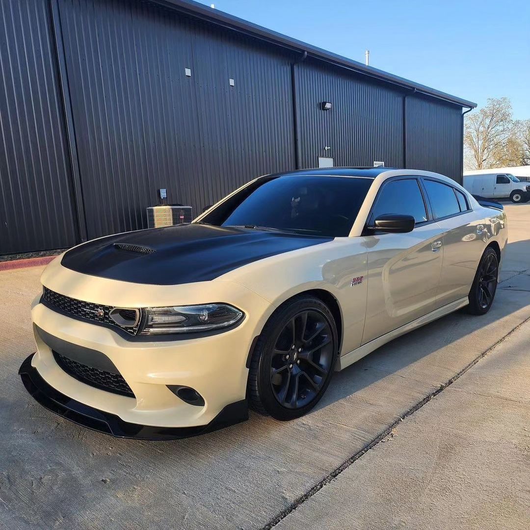 a white dodge charger is parked in front of a black building