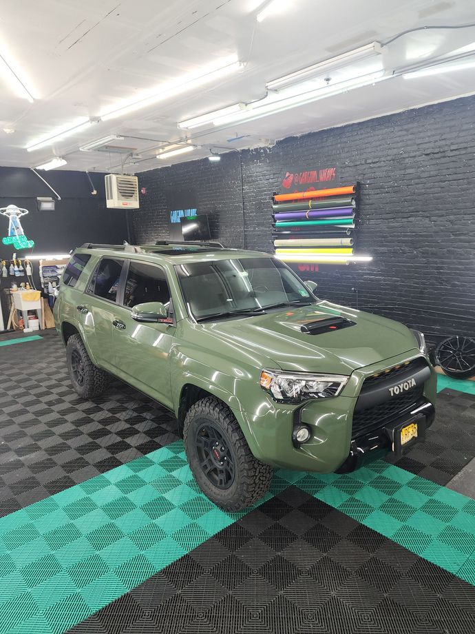 a green toyota 4runner is parked in a garage .