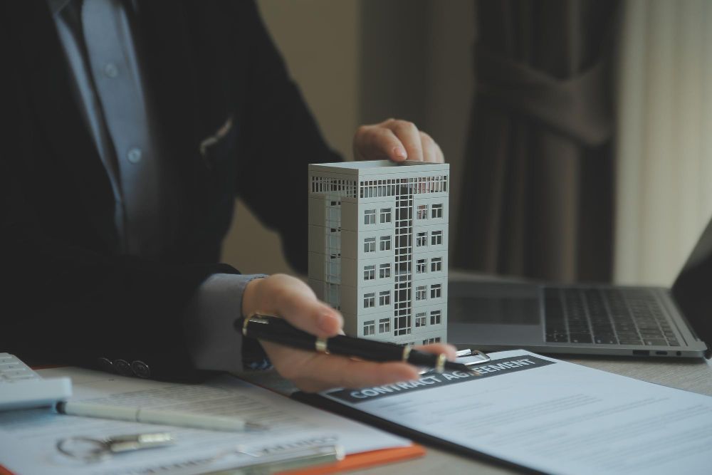 A man is holding a model of a building in his hands.