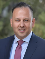 A man in a suit and tie is smiling for the camera.