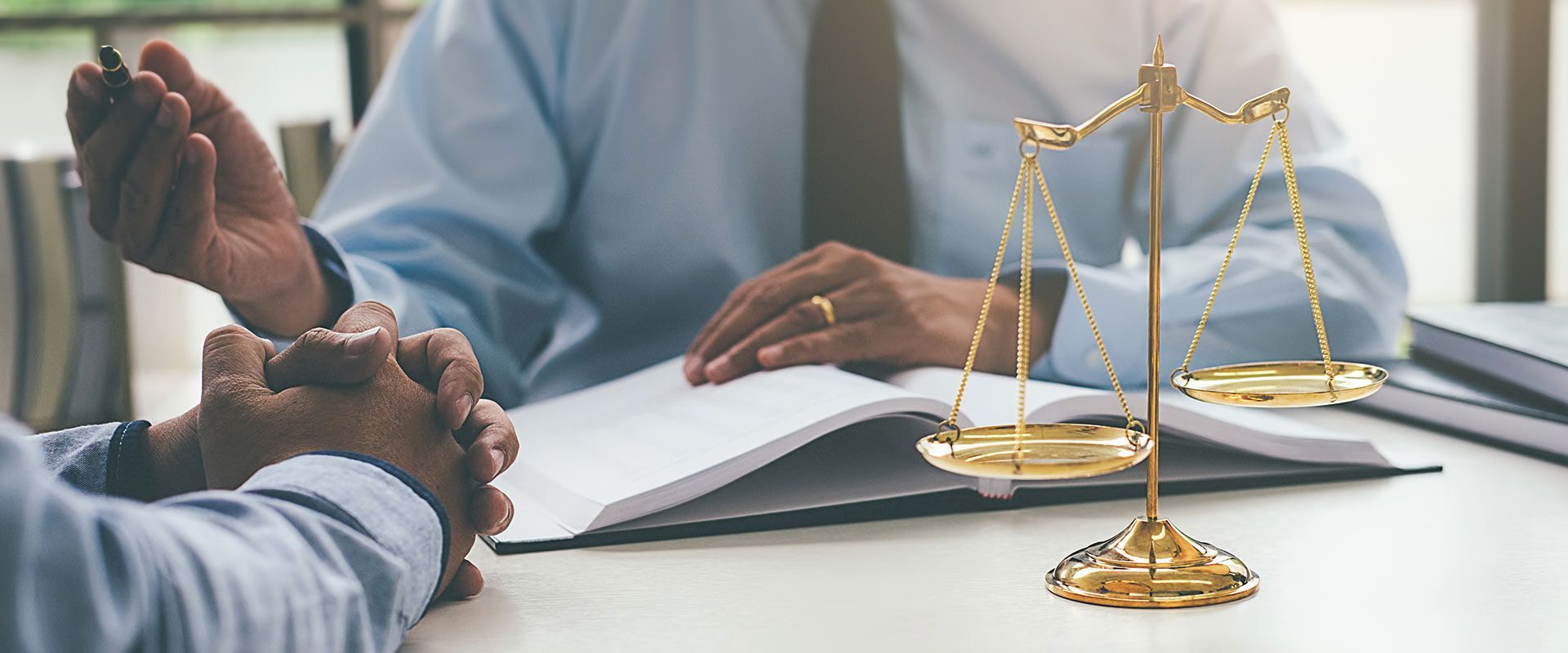 lawyer talking to client at the desk with justice scale