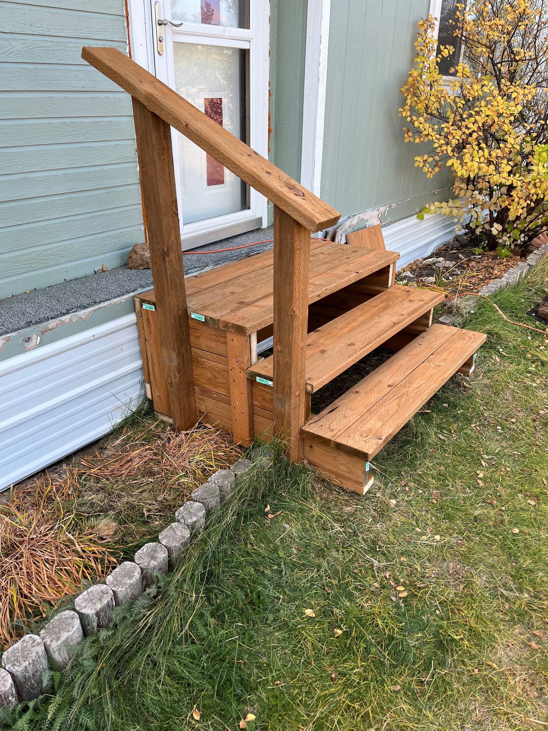 A wooden staircase is sitting in front of a house.