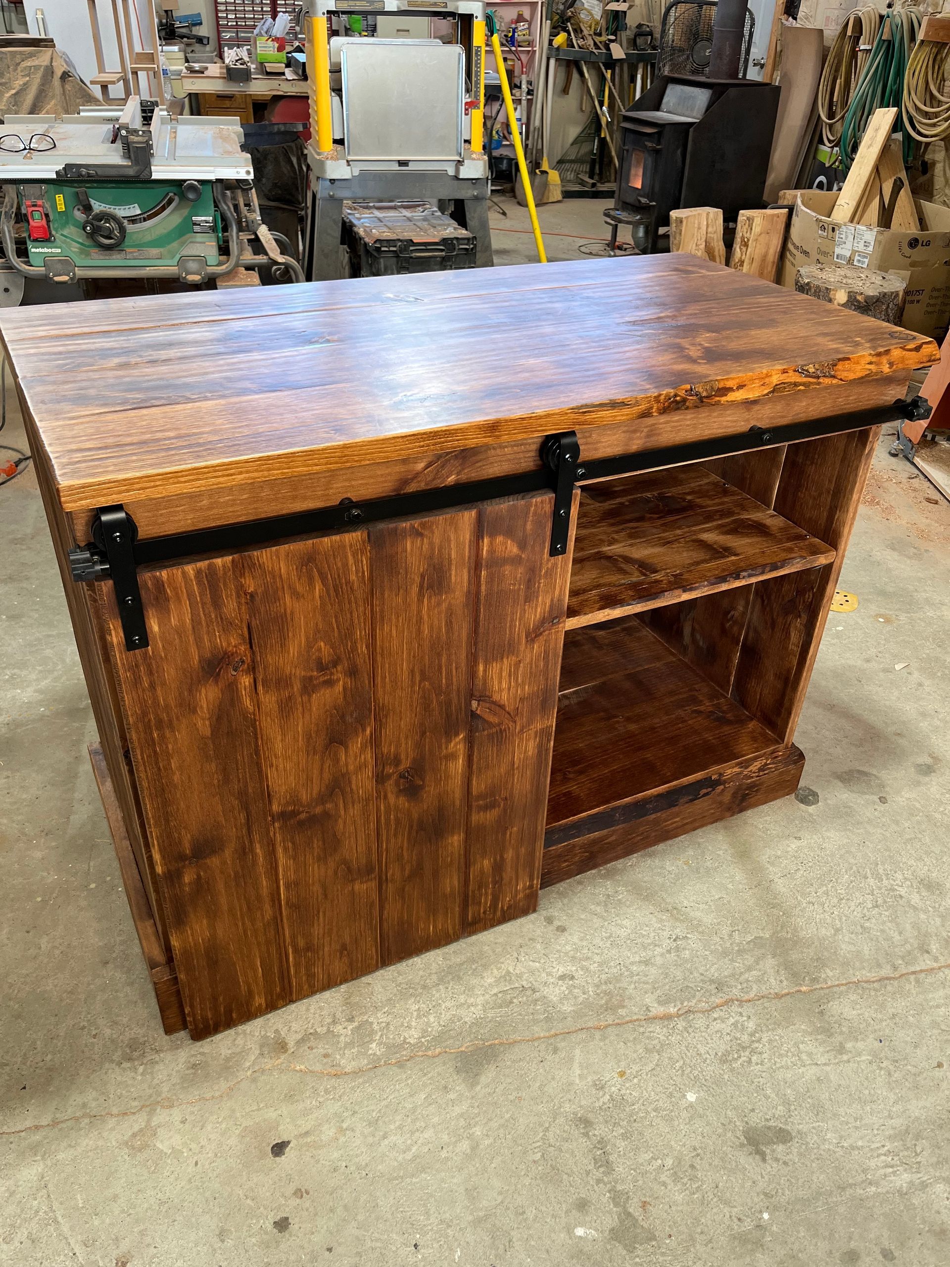 A wooden table with a sliding barn door in a workshop.