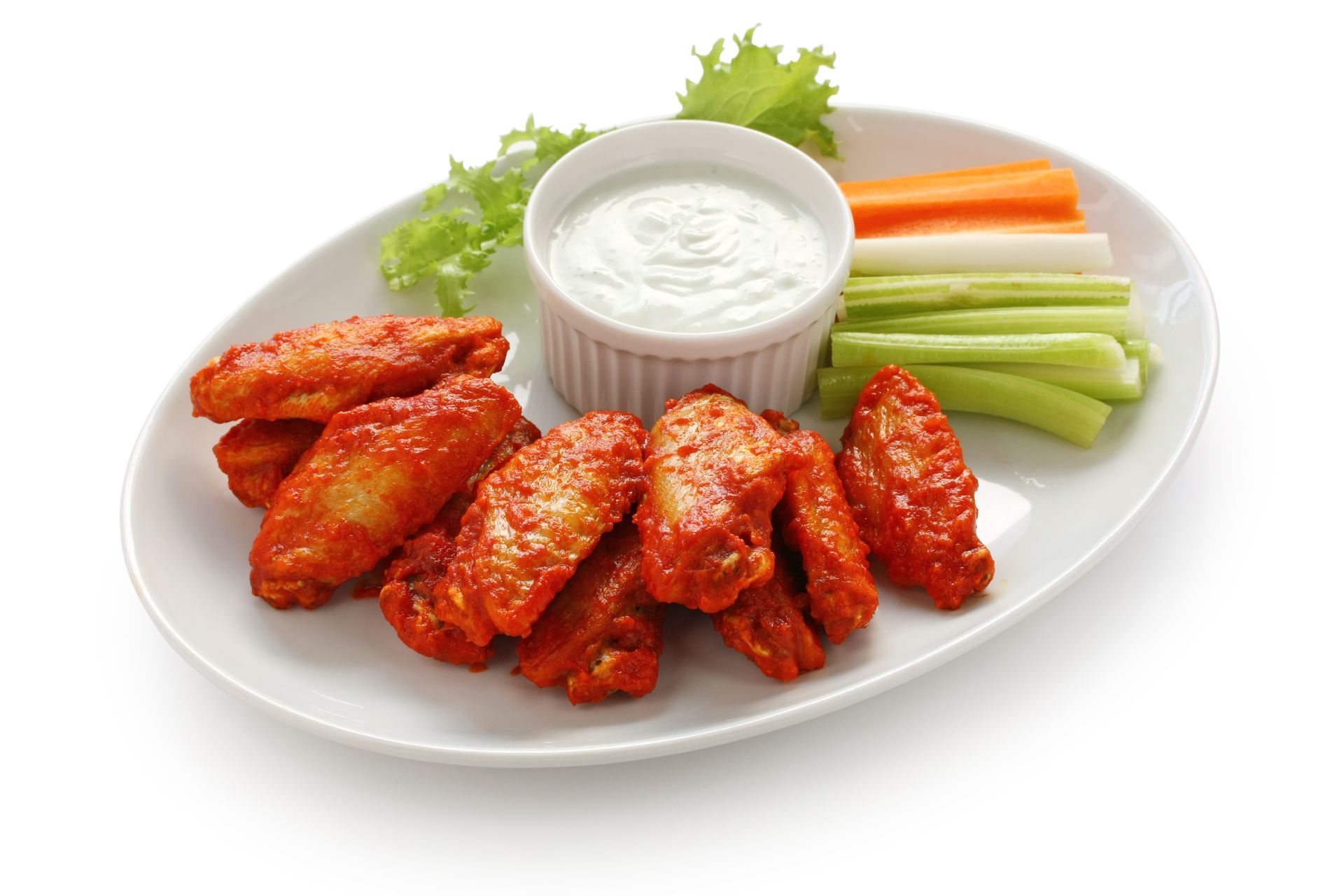 Buffalo wings with blue cheese, carrots, celery, and lettuce on a plate.