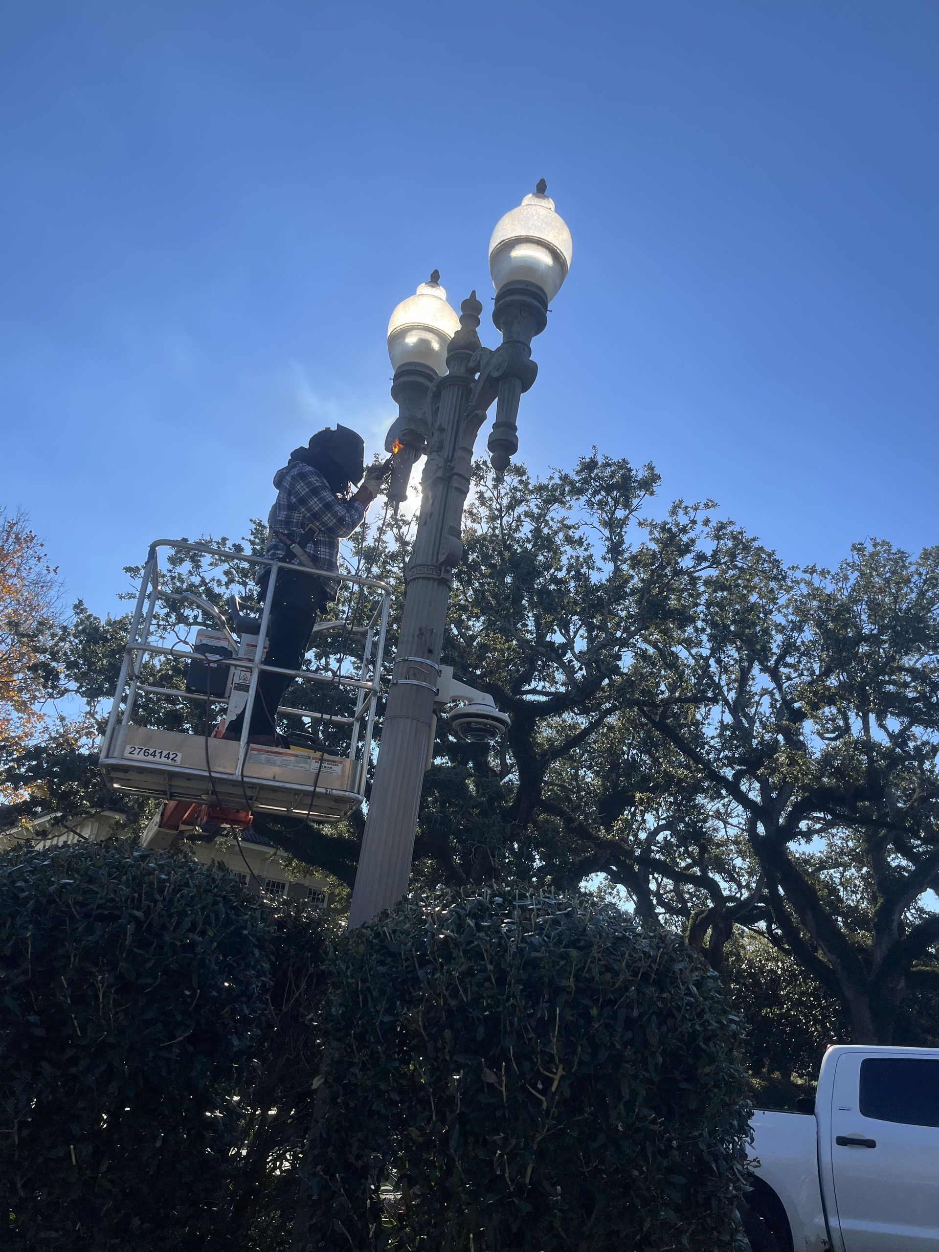 A man is working on a street light on a platform.