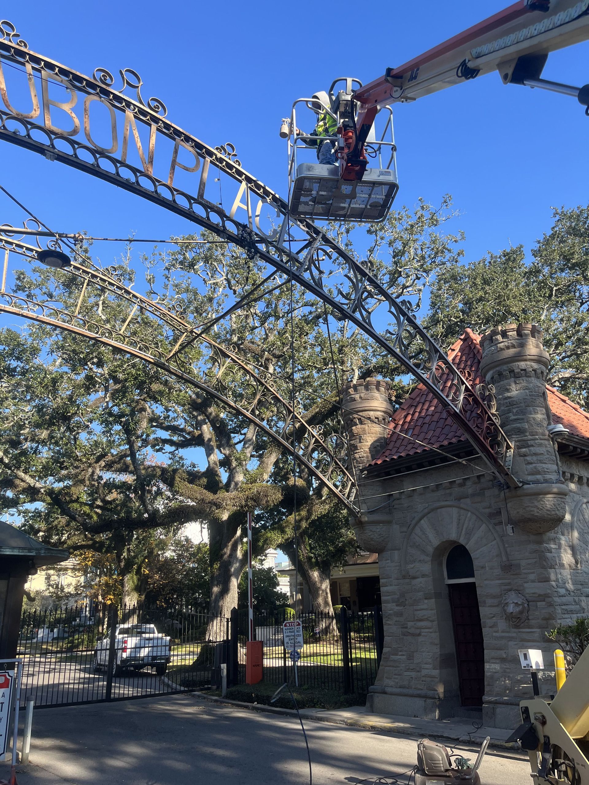 A man in a bucket is working on a crane in front of a building.